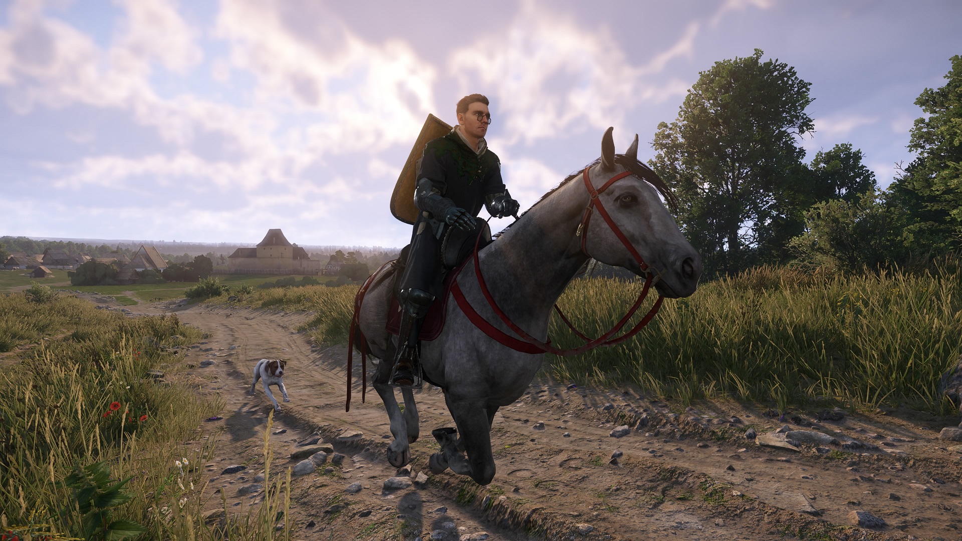 Скриншот из фильма «Kingdom Come: Deliverance 2», на котором Генри едет на своей серой лошади по кличке Пебблс, а за ним следует его собака Матт.