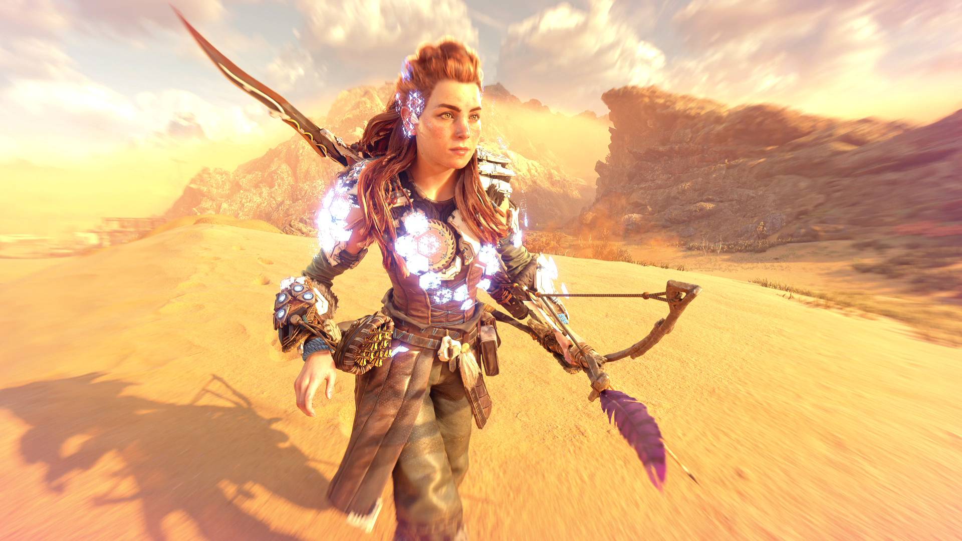 Скриншот из игры Horizons Forbidden West, на котором Элой в силовой броне идёт по бесплодной пустынной местности.